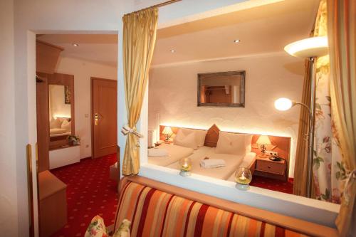 a hotel room with a large white couch in a room at ARNIKA Garni in Oberammergau