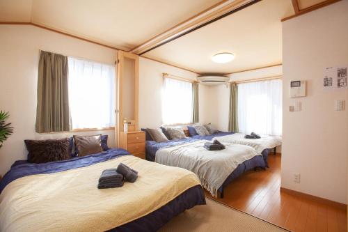 three beds in a room with windows at Lucky Higashimizue ラッキー東瑞江 in Tokyo