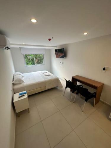 1 dormitorio con 1 cama, mesa y sillas en Hermoso Loft en Asuncion E1 en Asunción