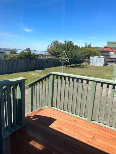 a wooden deck with a fence and a yard at Waterfront Lodge Motel in Hobart