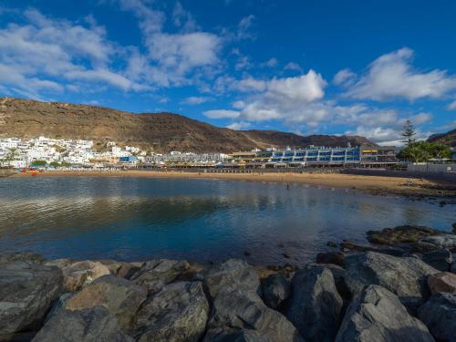 a view of a beach with buildings in the background at Sunny Valley Apartment in Mogán