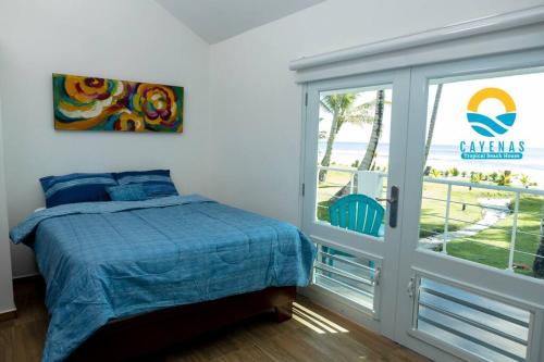 Schlafzimmer mit einem Bett und einer Glasschiebetür in der Unterkunft Beachfront Vacation Villa 