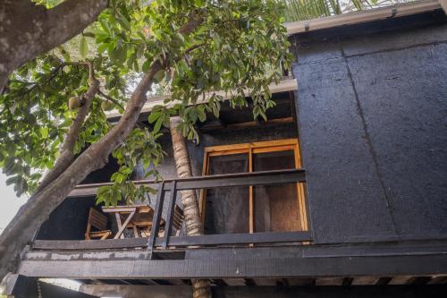 a tree house with a balcony and a tree at El Refugio de Sayulita - Solo Adultos in Sayulita