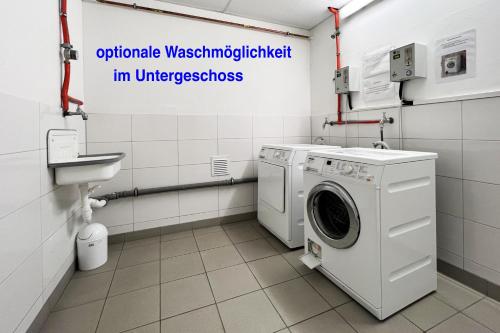 a bathroom with a washing machine and a sink at Villa Deichgraf Meerblick in Börgerende-Rethwisch