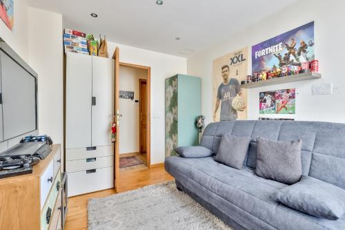 un salon avec un canapé et une télévision dans l'établissement Le Petit Peuplier, au Plessis-Robinson