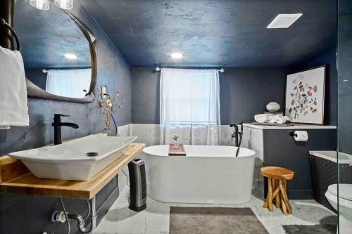 uma casa de banho com uma banheira grande e um lavatório em Summer Refresh-modern Comfort Near Downtown 40-4 em Oklahoma City