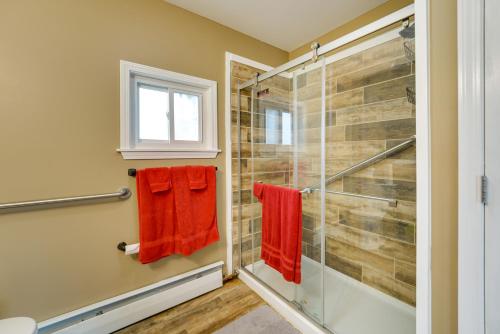 uma casa de banho com uma cabina de duche em vidro e toalhas vermelhas em Quiet Country Home By Shay Lake! 