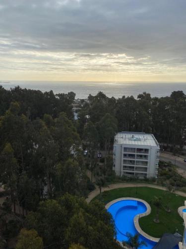 - une vue sur un bâtiment avec une piscine bleue dans l'établissement Departamento Costa Algarrobo Norte, à Yeco