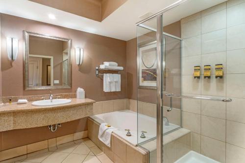 a bathroom with a shower and a sink and a tub at Best Western Plus Bayside Hotel in Oakland