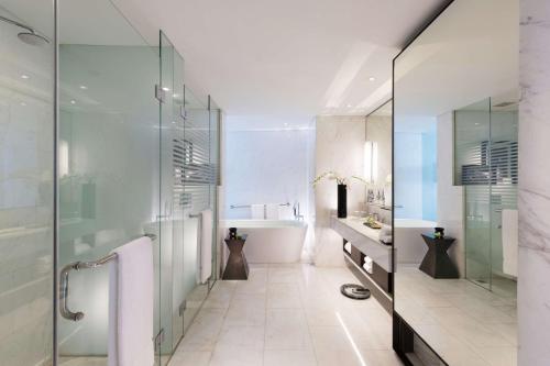 W łazience znajduje się przeszklony prysznic i wanna. w obiekcie DoubleTree by Hilton Jakarta - Diponegoro w Dżakarcie