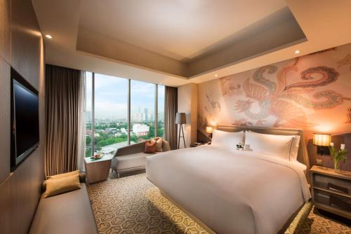 een hotelkamer met een groot bed en een televisie bij DoubleTree by Hilton Jakarta - Diponegoro in Jakarta