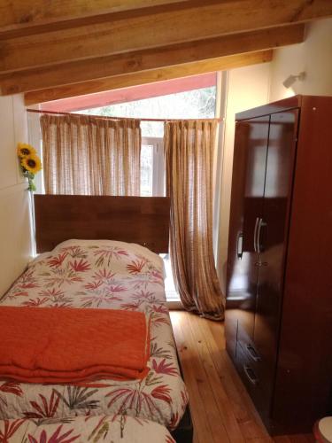 um quarto com uma cama e uma grande janela em Amacoa em Puerto Varas