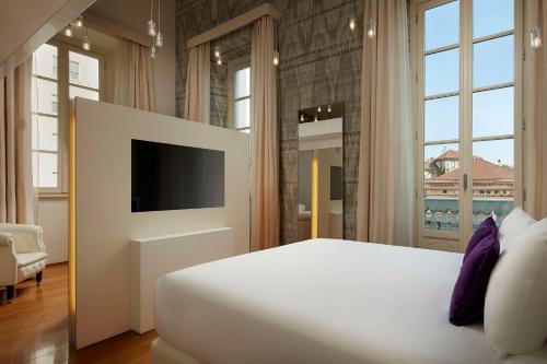 - une chambre avec un grand lit et une télévision dans l'établissement Avani Palazzo Moscova Milan Hotel -Previously NH Palazzo Moscova-, à Milan