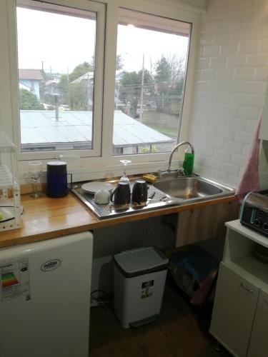 encimera de cocina con fregadero y ventana en Amacoa, en Puerto Varas