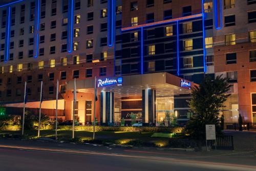 un edificio con luces azules al lado de una calle en Radisson Blu Hotel, Cairo Heliopolis, en El Cairo