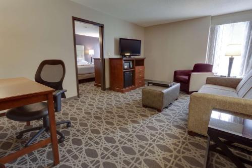 a room with a living room with a couch and a tv at Drury Inn & Suites Overland Park in Overland Park