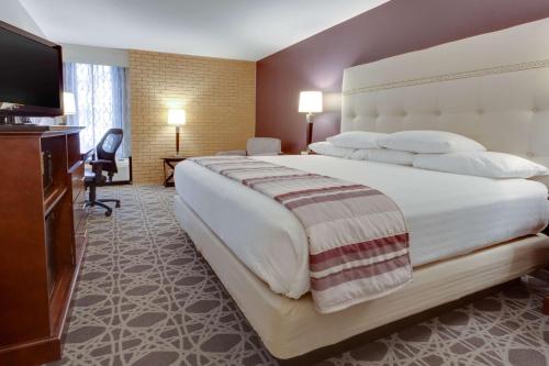 a hotel room with a large bed and a flat screen tv at Drury Inn & Suites Overland Park in Overland Park