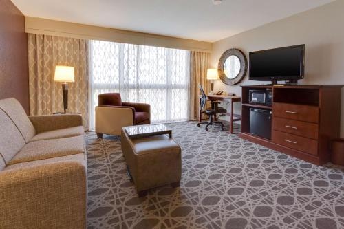 a living room with a couch and a flat screen tv at Drury Inn & Suites Overland Park in Overland Park