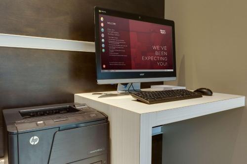 a computer monitor on a desk with a keyboard and mouse at Drury Inn & Suites Overland Park in Overland Park