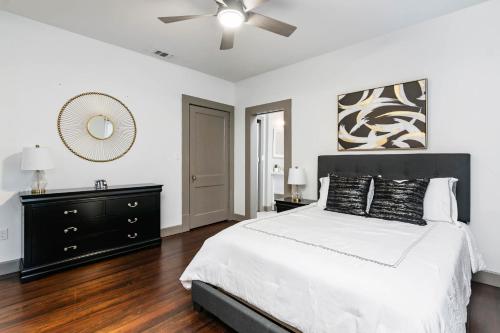 a white bedroom with a bed and a ceiling fan at Chic Comforts in Tobin. in San Antonio