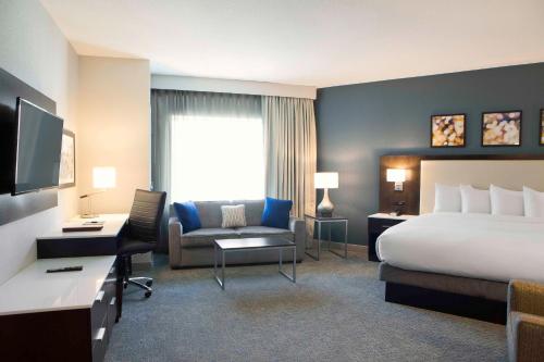 a hotel room with a bed and a desk and a chair at Hilton Garden Inn Minneapolis - University Area in Minneapolis