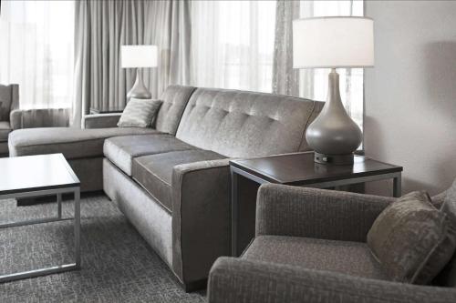 a living room with a couch and a lamp on a table at Hilton Garden Inn Minneapolis - University Area in Minneapolis