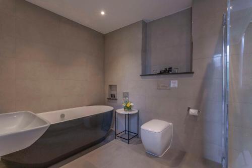 y baño con bañera, aseo y lavamanos. en Oatlands Park Hotel en Weybridge