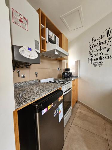 a kitchen with a black refrigerator and a stove at Comarca Fueguina in Ushuaia