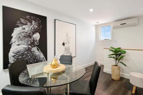a dining room with a glass table and chairs at City Centre Unit Overlooking Ryrie Street! in Geelong