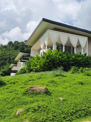 a house on top of a grassy hill at เฌอปือ เชียงใหม่ Cherpue Chiangmai in Ban Mae Na