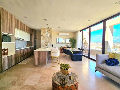 a kitchen and living room with a couch and a table at Amazing Panoramic View from Penthouse in Pedregal in Cabo San Lucas