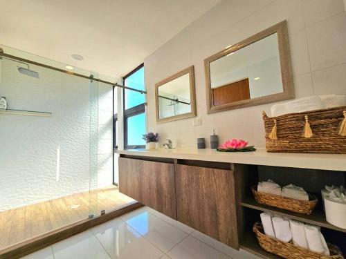 a bathroom with a shower and a sink and a mirror at Amazing Panoramic View from Penthouse in Pedregal in Cabo San Lucas