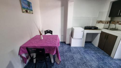 a small kitchen with a purple table and chairs at Hostel Stingray in San Andrés
