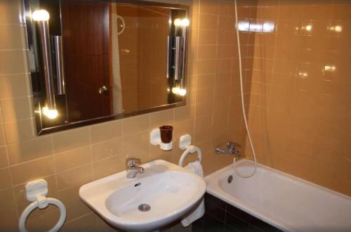 La salle de bains est pourvue d'un lavabo, d'un miroir et d'une baignoire. dans l'établissement Apartamento 1ª linea de mar, à Sant Carles de la Ràpita