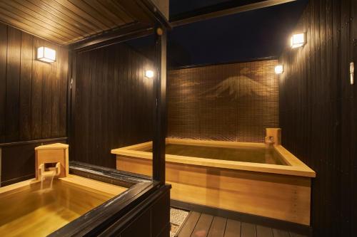 a bath tub in a wooden room with lights at SAKE Bar Hotel Asakusa in Tokyo