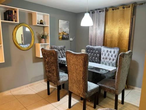 una sala da pranzo con tavolo, sedie e specchio di Hermosos apartamentos tu casa a La Javilla