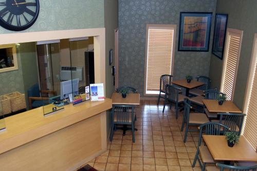 a restaurant with tables and chairs and a clock on the wall at Super 8 by Wyndham Mount Vernon, IL in Mount Vernon