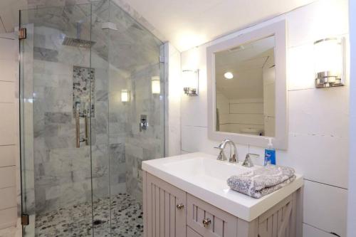 a bathroom with a sink and a shower with a mirror at Gem in Midtown 4bedroom home-11 in Atlanta
