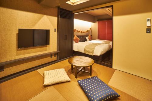Cette chambre comprend 2 lits et une télévision à écran plat. dans l'établissement SAKE Bar Hotel Asakusa, à Tokyo