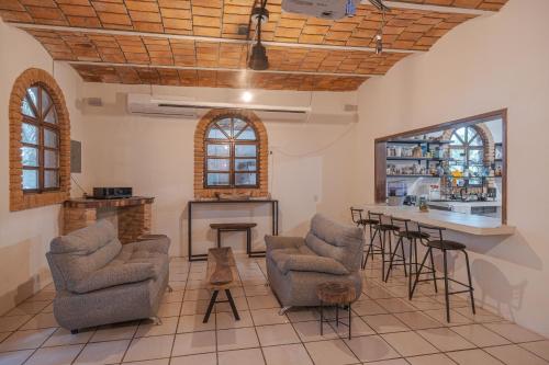 a living room with two chairs and a bar at El Refugio de Sayulita - Solo Adultos in Sayulita