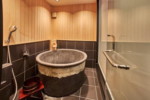 ein Bad mit einer großen Eckbadewanne in der Unterkunft SAKE Bar Hotel Asakusa in Tokio