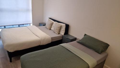 twee bedden in een kleine kamer met sidx sidx sidx sidx bij Modern-New Build Apartment in Birmingham in Birmingham