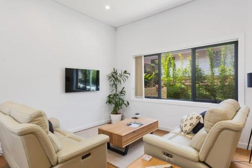 a living room with two chairs and a coffee table at Avenue Escape - Contemporary Living at Corrimal in Wollongong