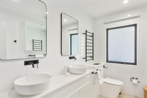 a white bathroom with two sinks and a mirror at Avenue Escape - Contemporary Living at Corrimal in Wollongong