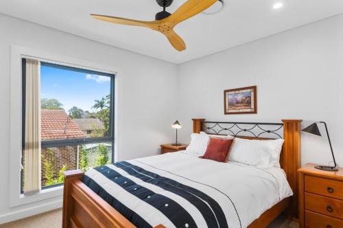 1 dormitorio con cama y ventana en Avenue Escape - Contemporary Living at Corrimal en Corrimal