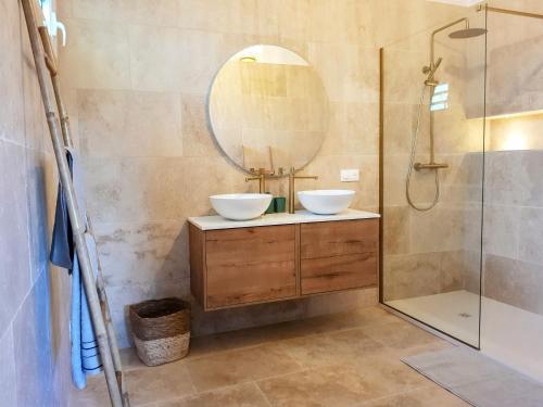 Baño con 2 lavabos y espejo en La villa d'Emma, en Sainte-Anne