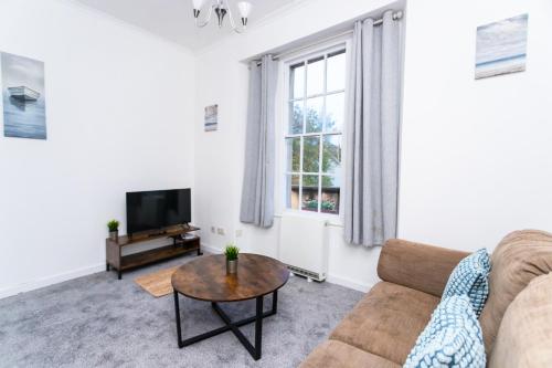 a living room with a couch and a tv at May Disc - Long Stay - Contractors in Bristol