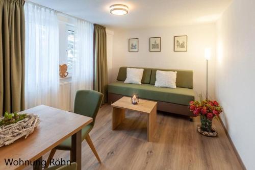 salon z kanapą i stołem w obiekcie Gästehaus Zur Quelle w mieście Wächtersbach