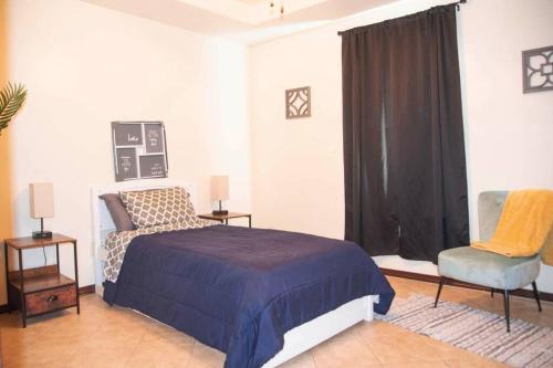 a bedroom with a bed and a chair and a window at 3BD 2BT town suite minutes away Medical Center in Edinburg