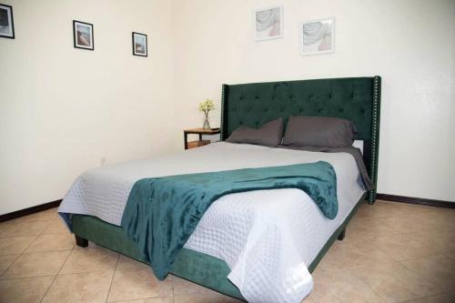 ein großes Bett mit einem grünen Kopfteil in einem Schlafzimmer in der Unterkunft Modern 2 bed 2-bath next to University UTRGV in Edinburg